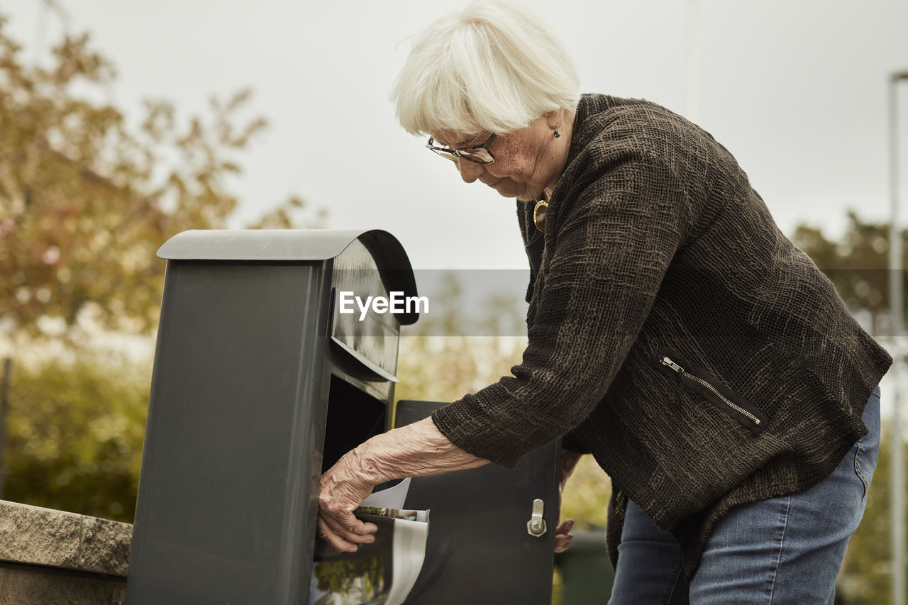 Senior woman standing near mailbox