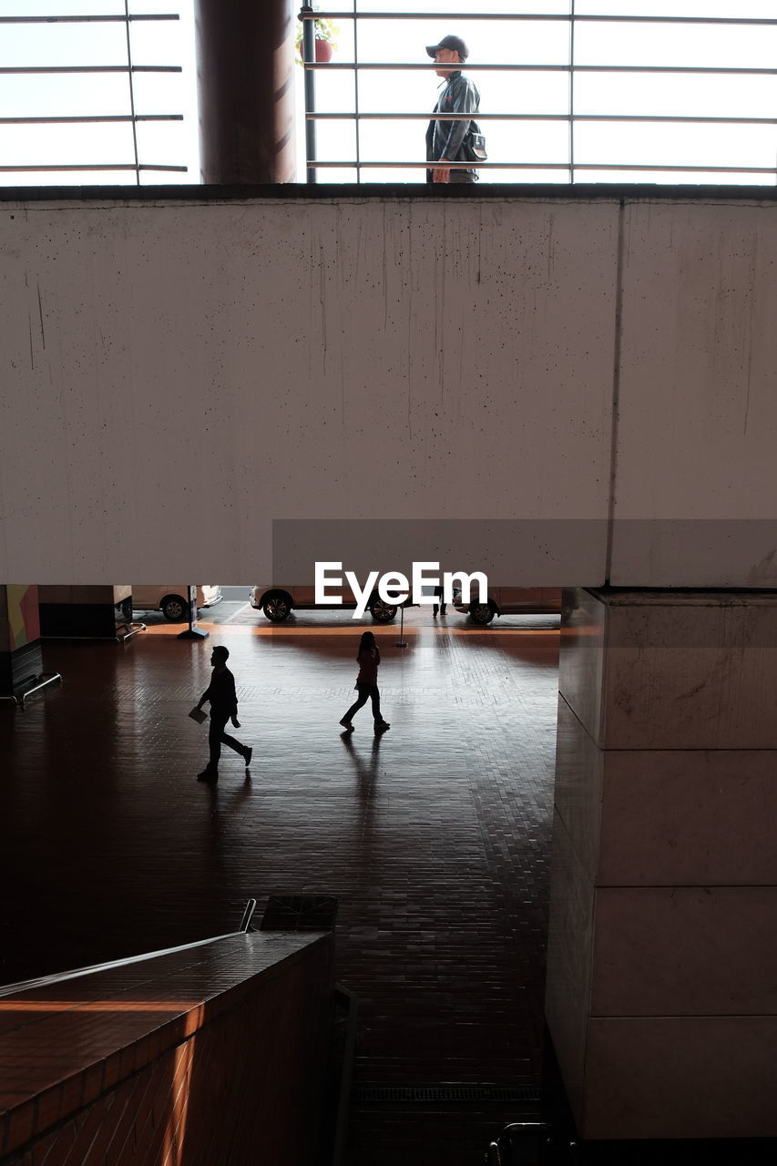 PEOPLE STANDING ON RAILING OF BUILDING