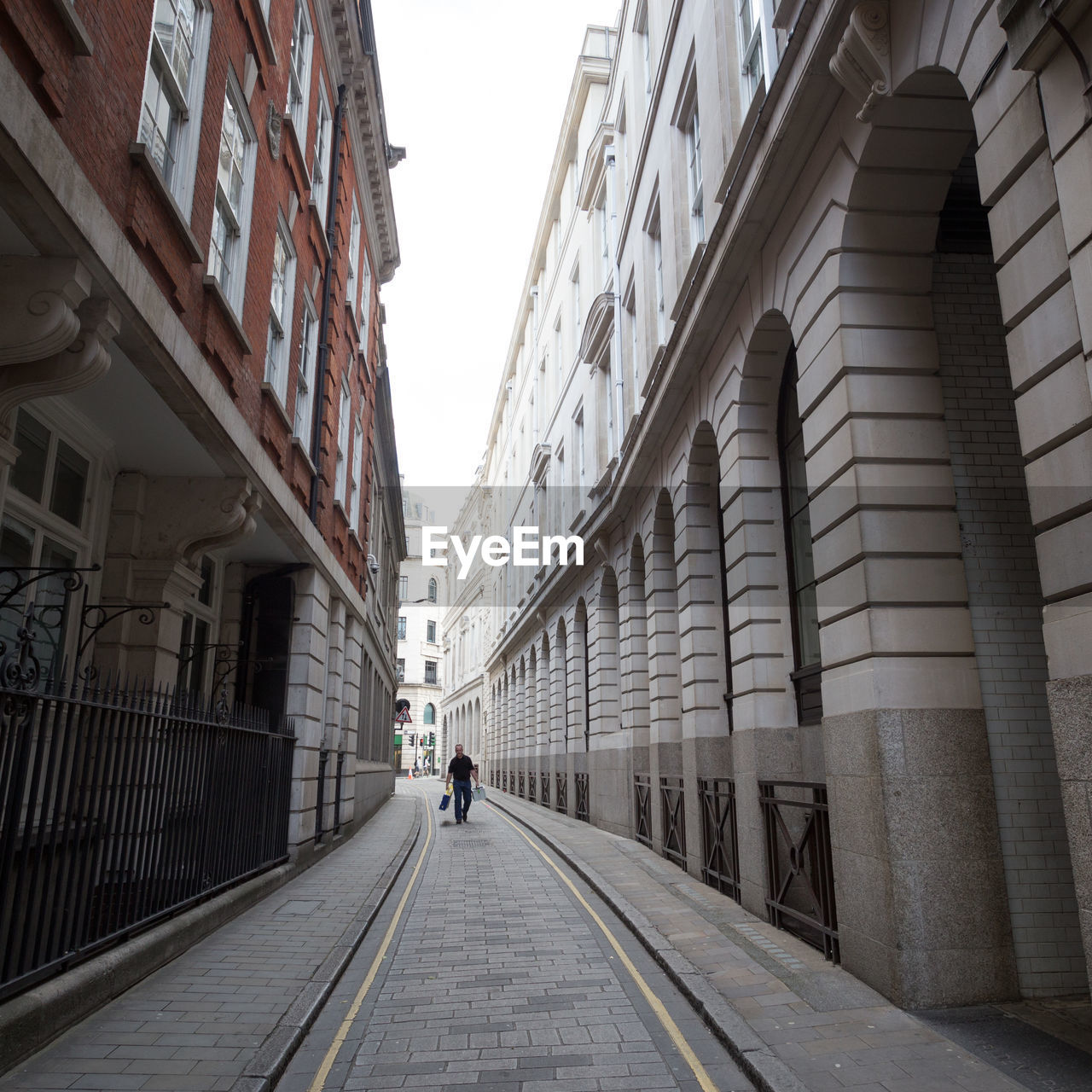 REAR VIEW OF PEOPLE WALKING ON ROAD