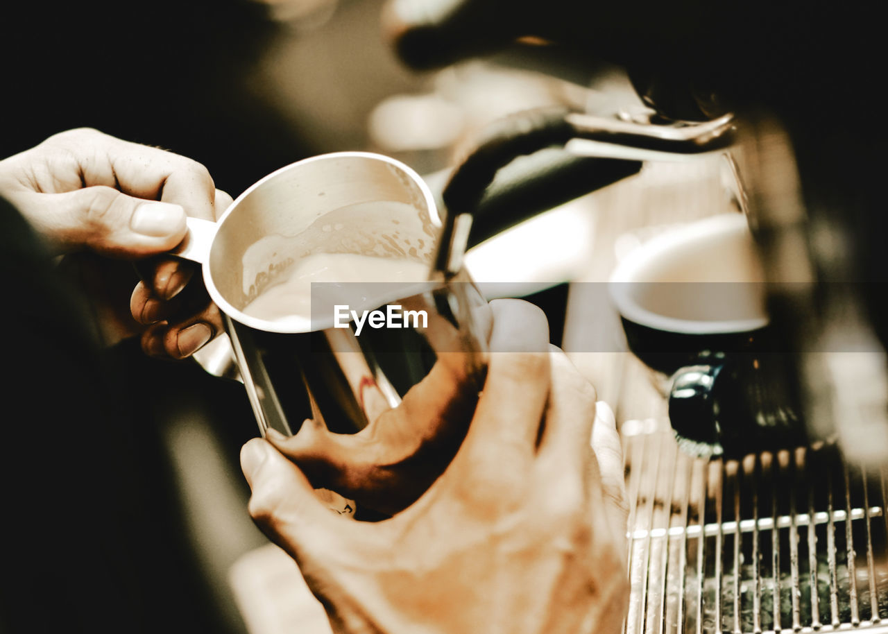 CLOSE-UP OF HAND HOLDING COFFEE