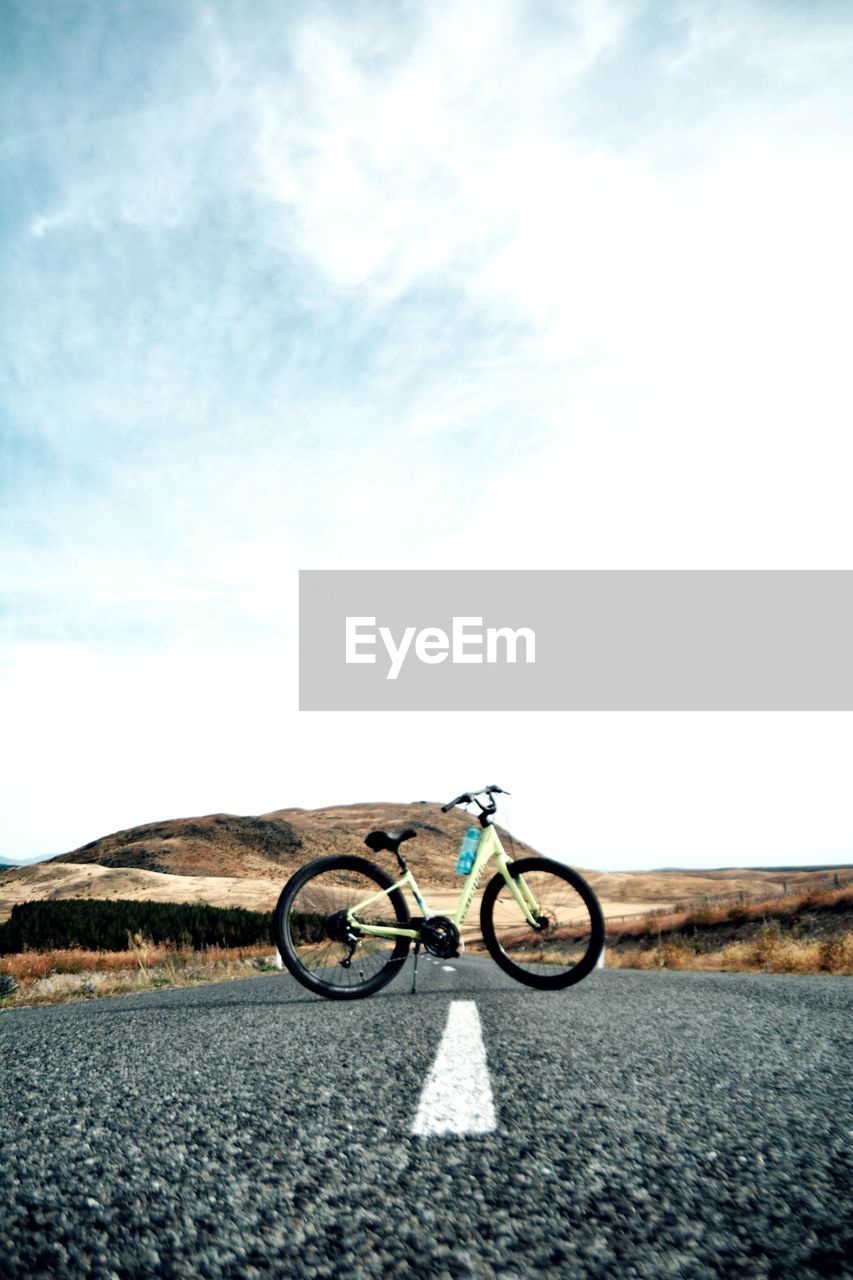 BICYCLE ON WALL AGAINST SKY