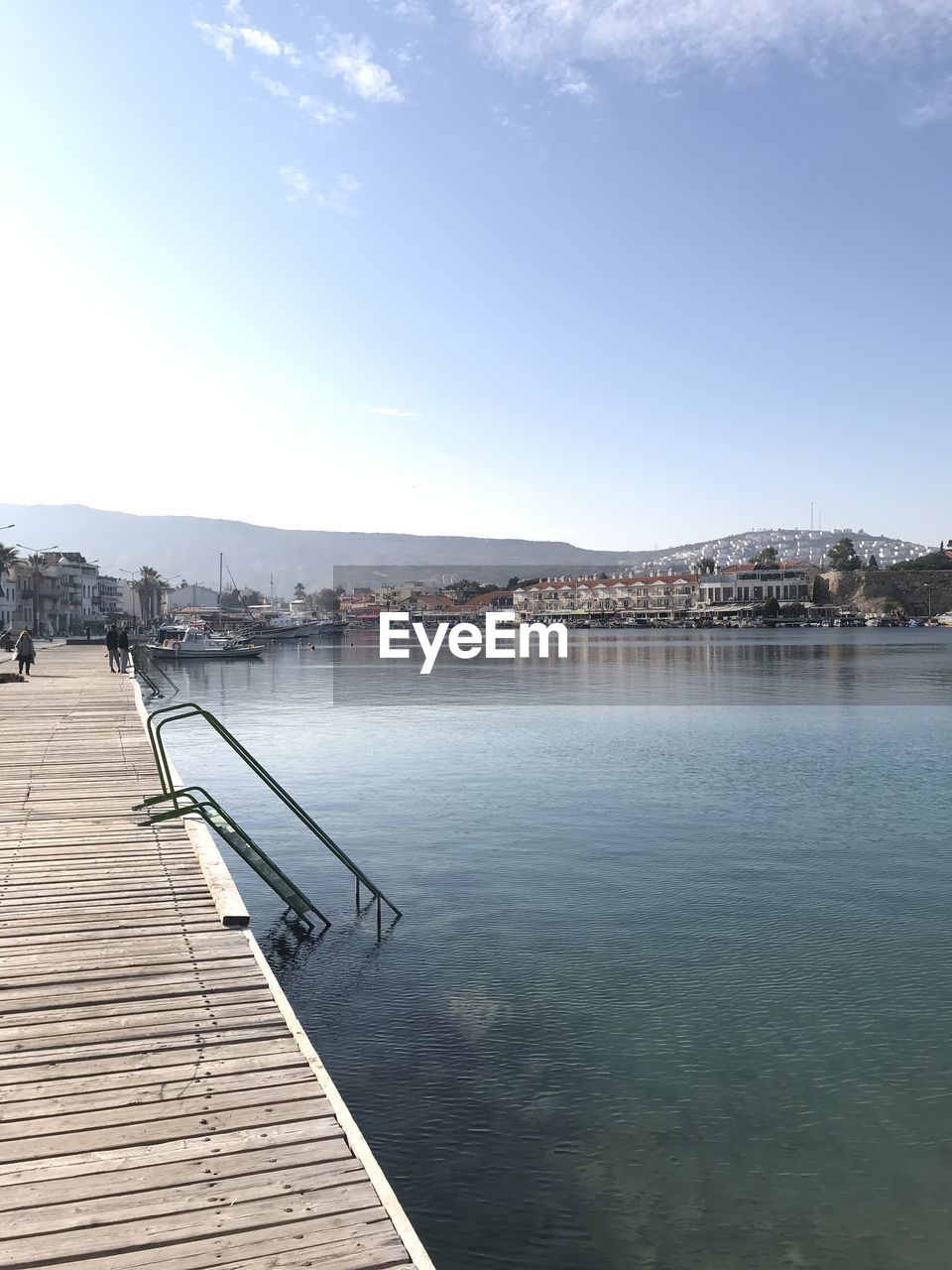 Pier over lake in city against sky