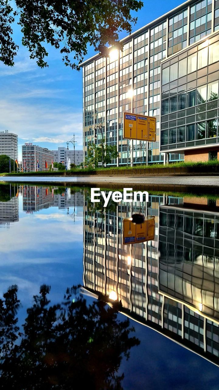 architecture, built structure, reflection, building exterior, urban area, water, city, building, nature, sky, tree, no people, plant, outdoors, office building exterior, downtown, travel destinations, office, landmark, day, cityscape, metropolitan area, business, facade, travel, transportation