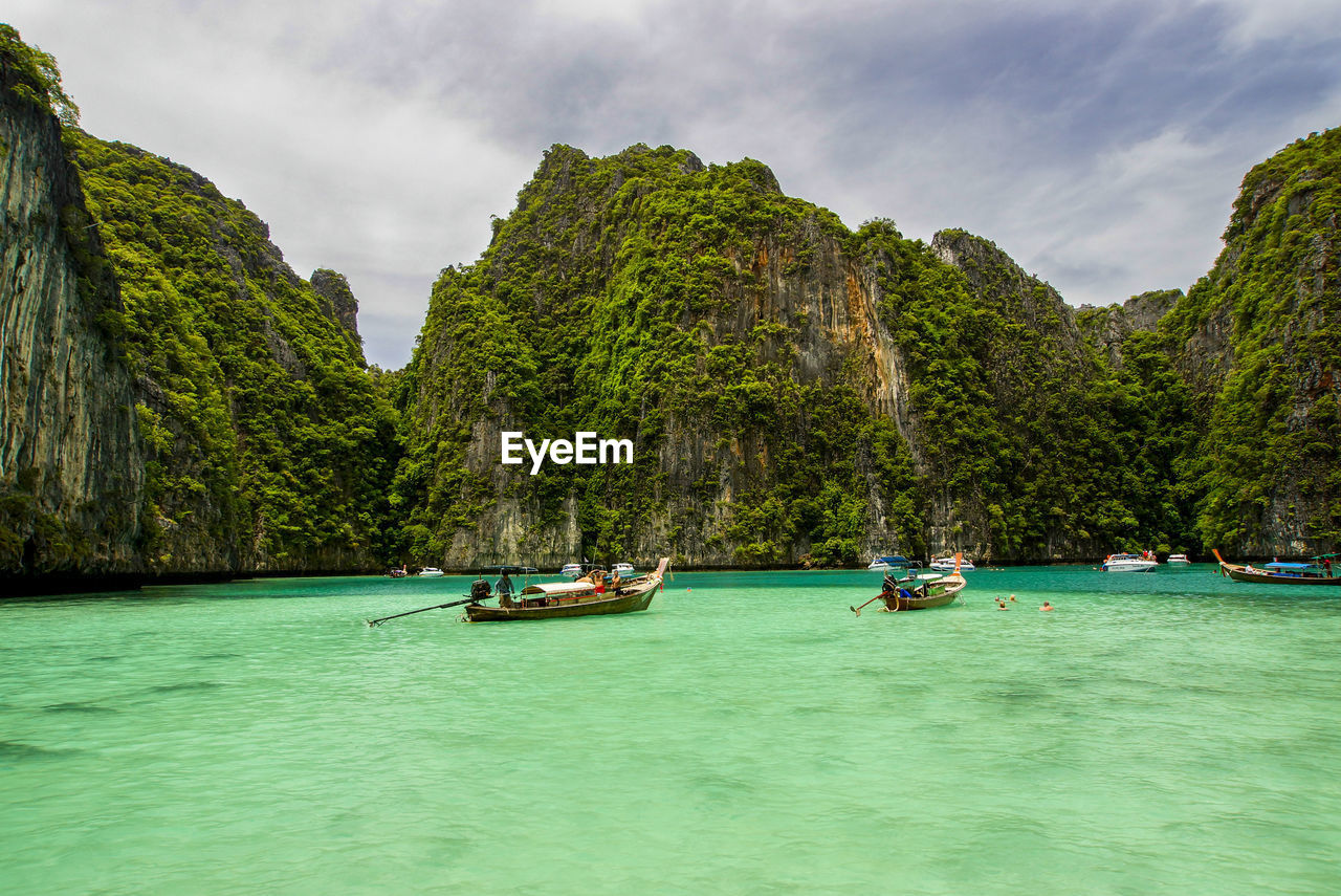 Scenic view of sea and rock formations against cloudy sky