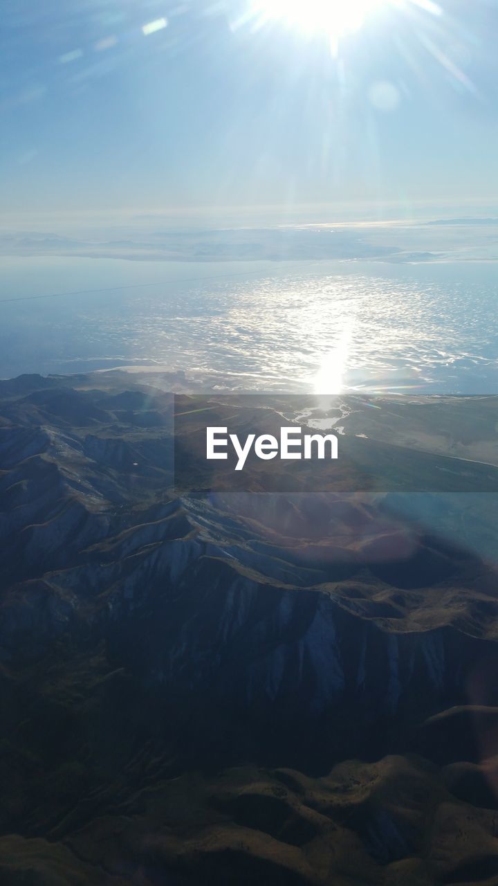 High angle view of mountains by sea against sky