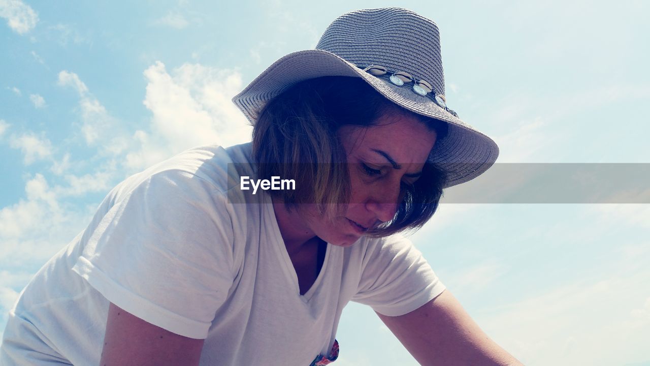 Low angle view of mature woman wearing hat