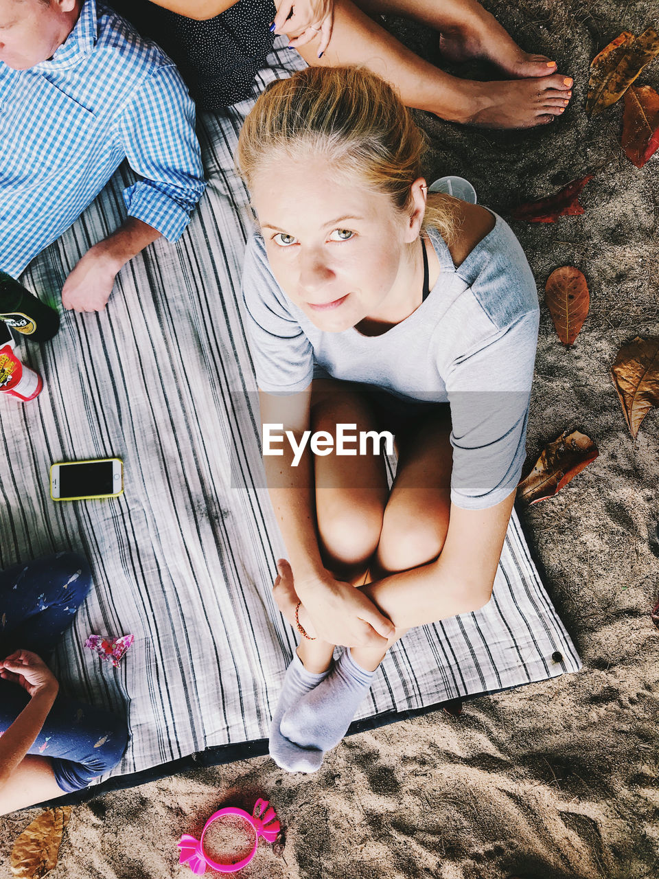 HIGH ANGLE VIEW OF MOTHER AND WOMAN SITTING ON FLOOR