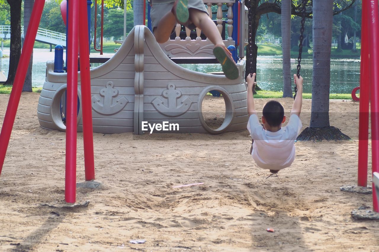 Children playing on swing in playground