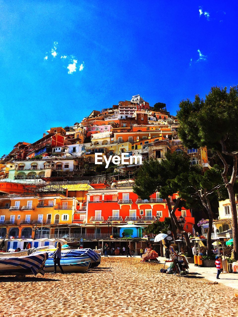 Residential buildings by beach against blue sky