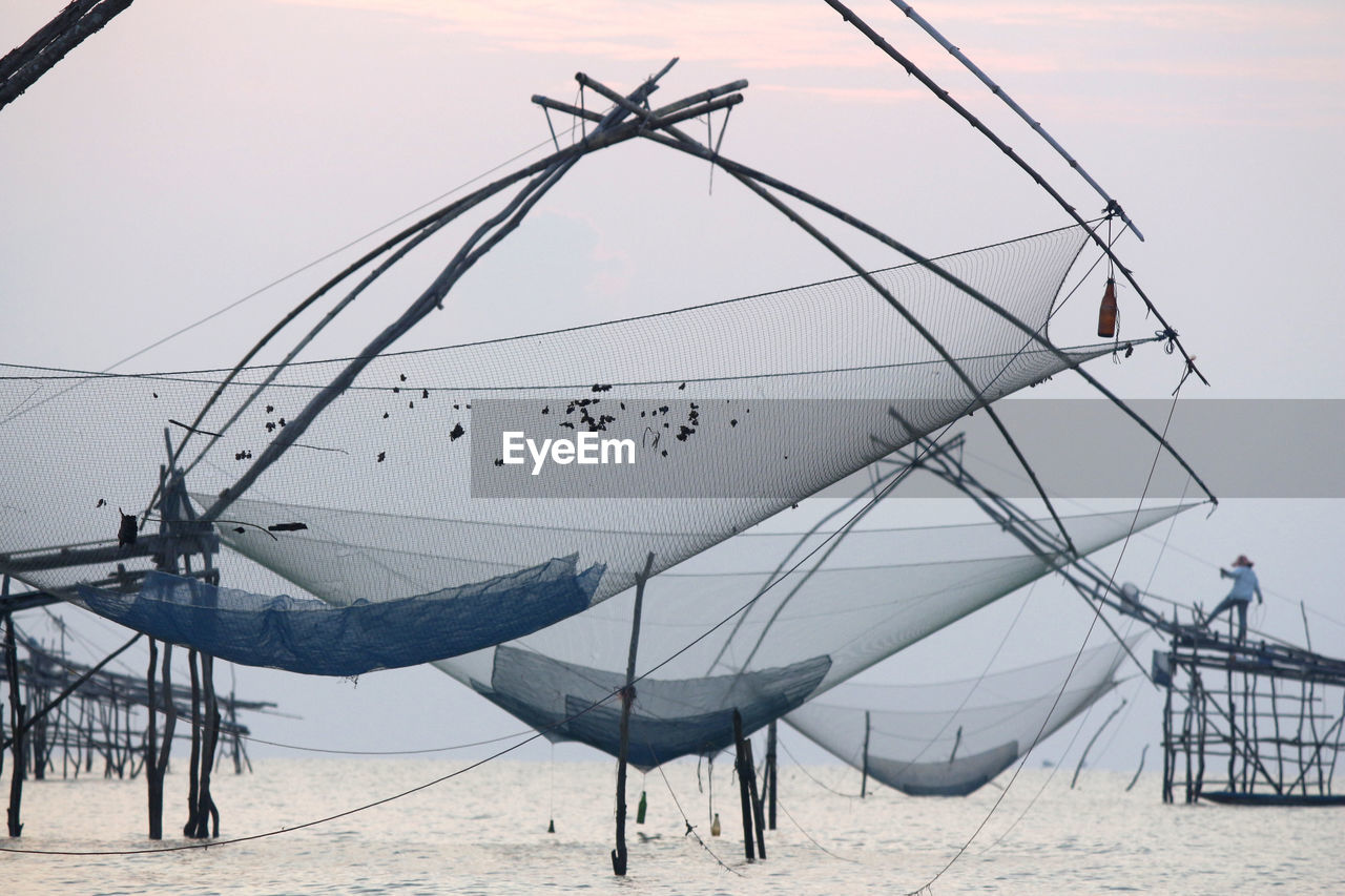 View of fishing nets at beach against sky