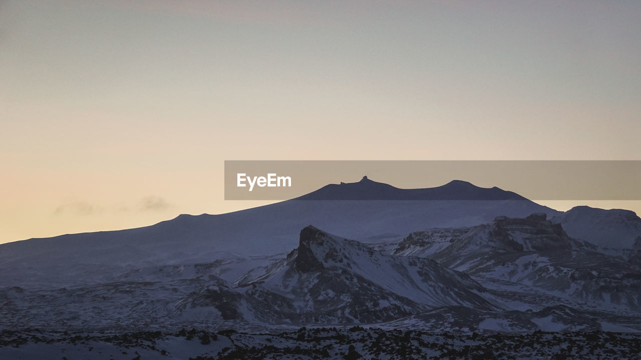 Scenic view of snowcapped mountains against sky during sunset