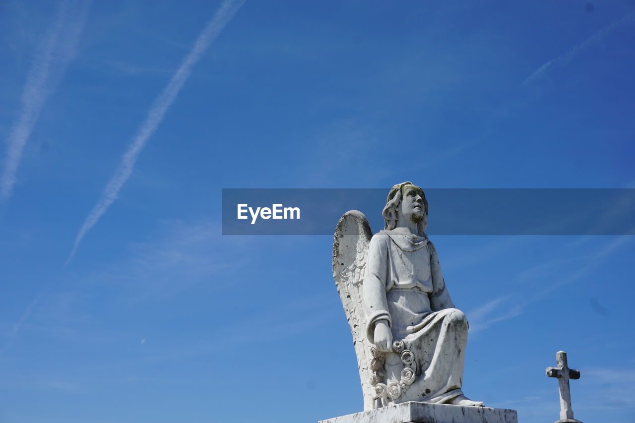 Low angle view of statue against blue sky