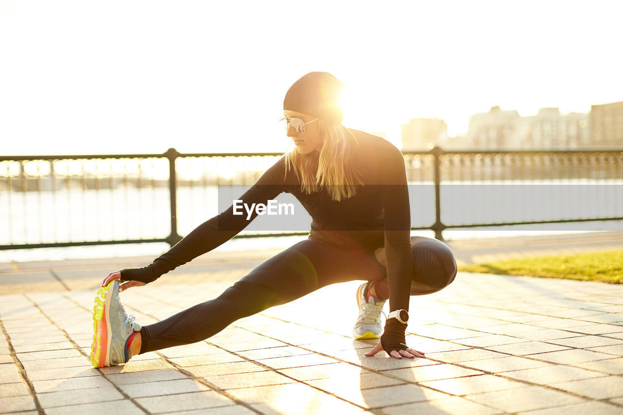 A woman stretching in the sunshine.