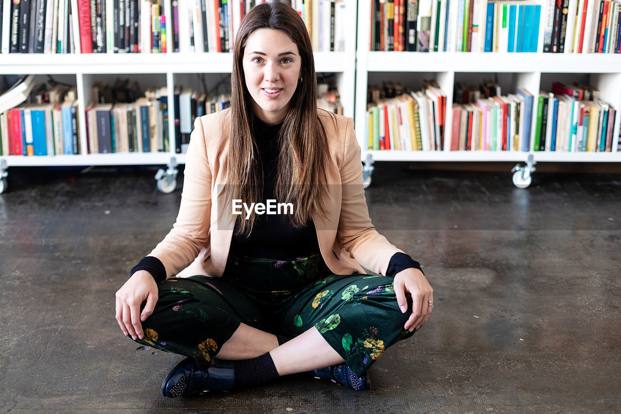 Portrait of smiling woman sitting at library