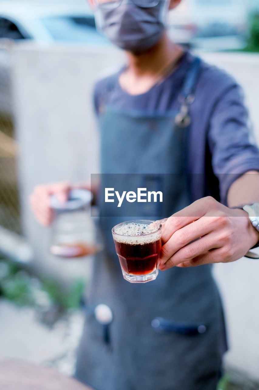 MIDSECTION OF MAN HOLDING BEER GLASS