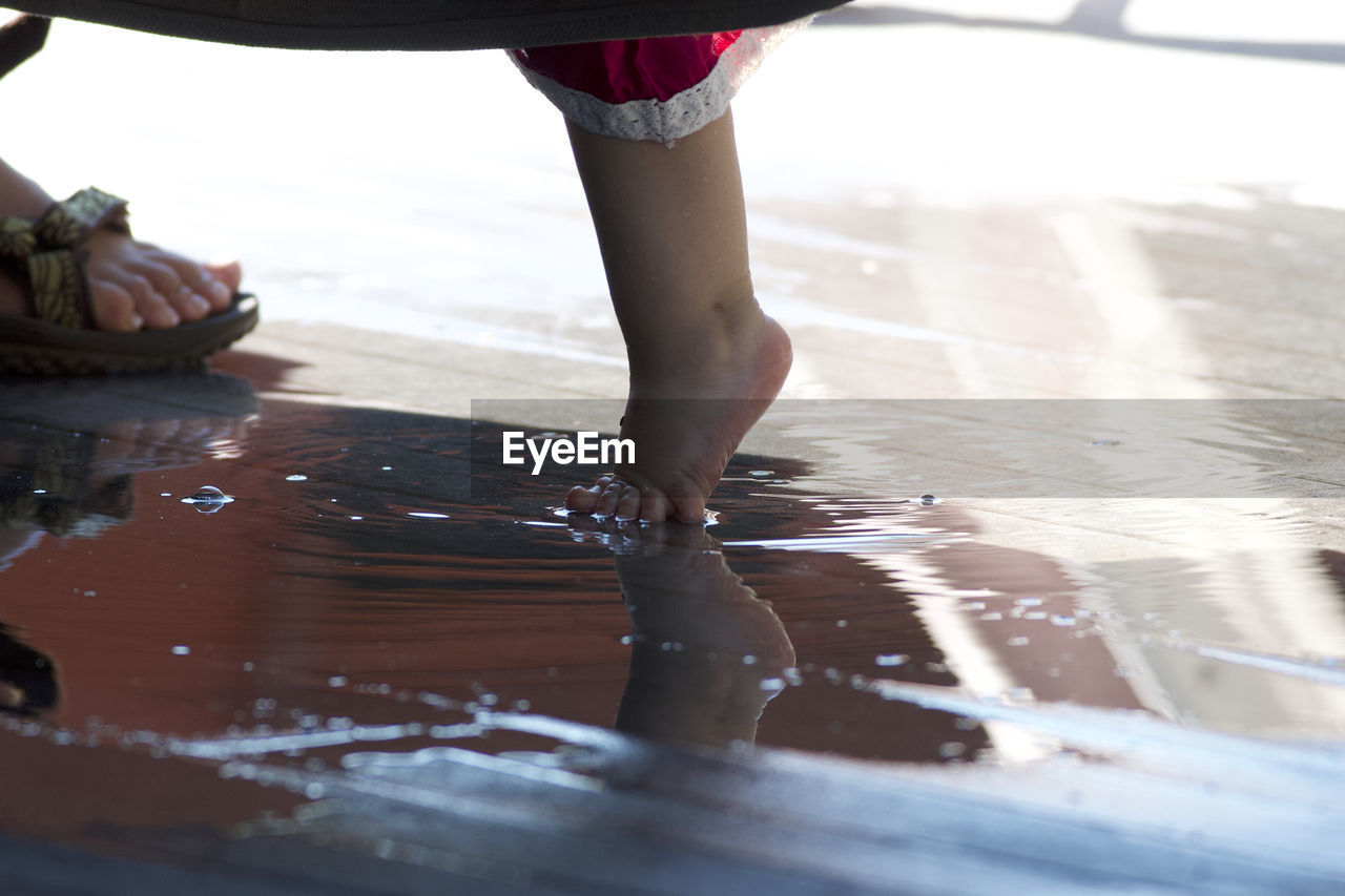 Close-up of cute girl standing by puddle outdoors