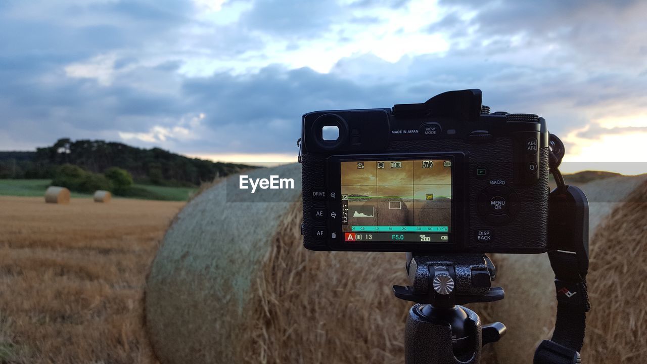 Close-up of camera by hay bale