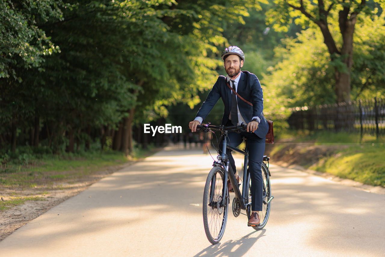 side view of man riding bicycle on road