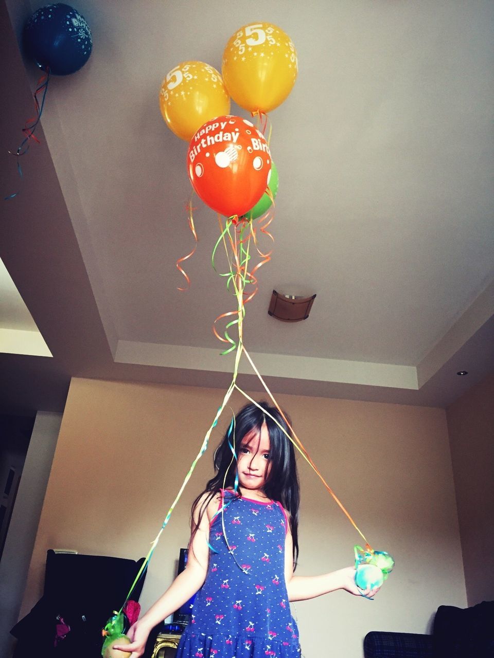 Portrait of cute girl with balloons at home