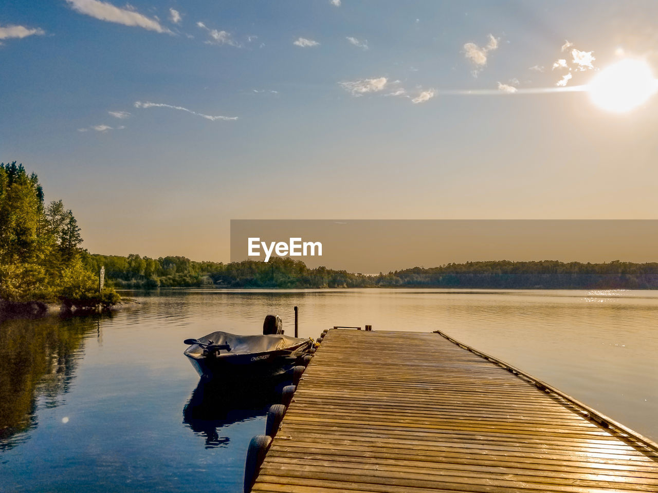 BOAT IN LAKE AGAINST SKY DURING SUNSET