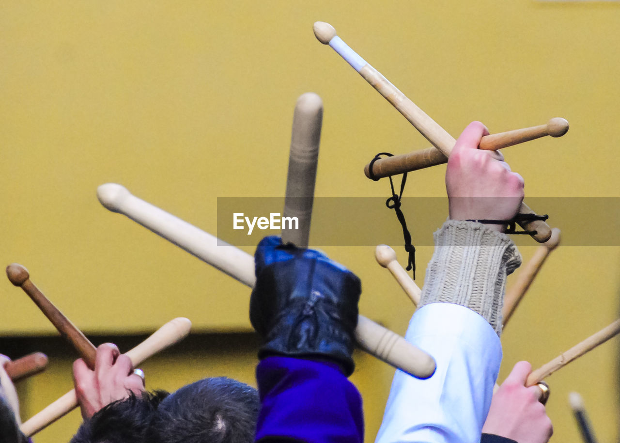 Cropped hands raised with wooden sticks during holy week