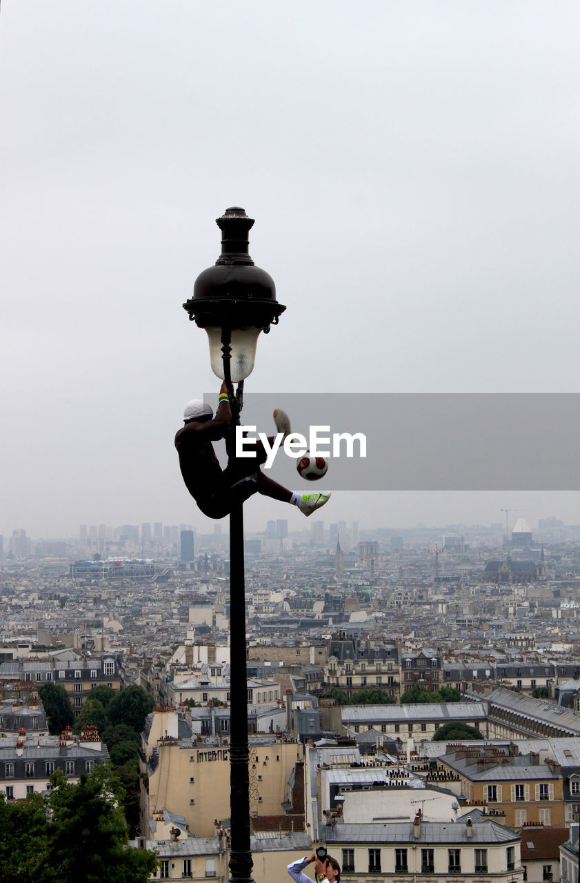 Man hanging on street light