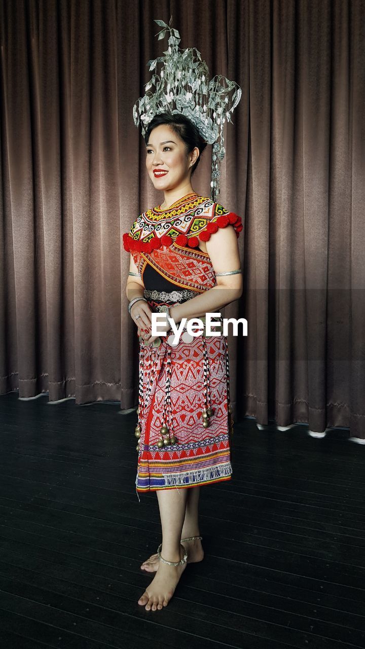 Smiling woman wearing traditional clothing standing on stage