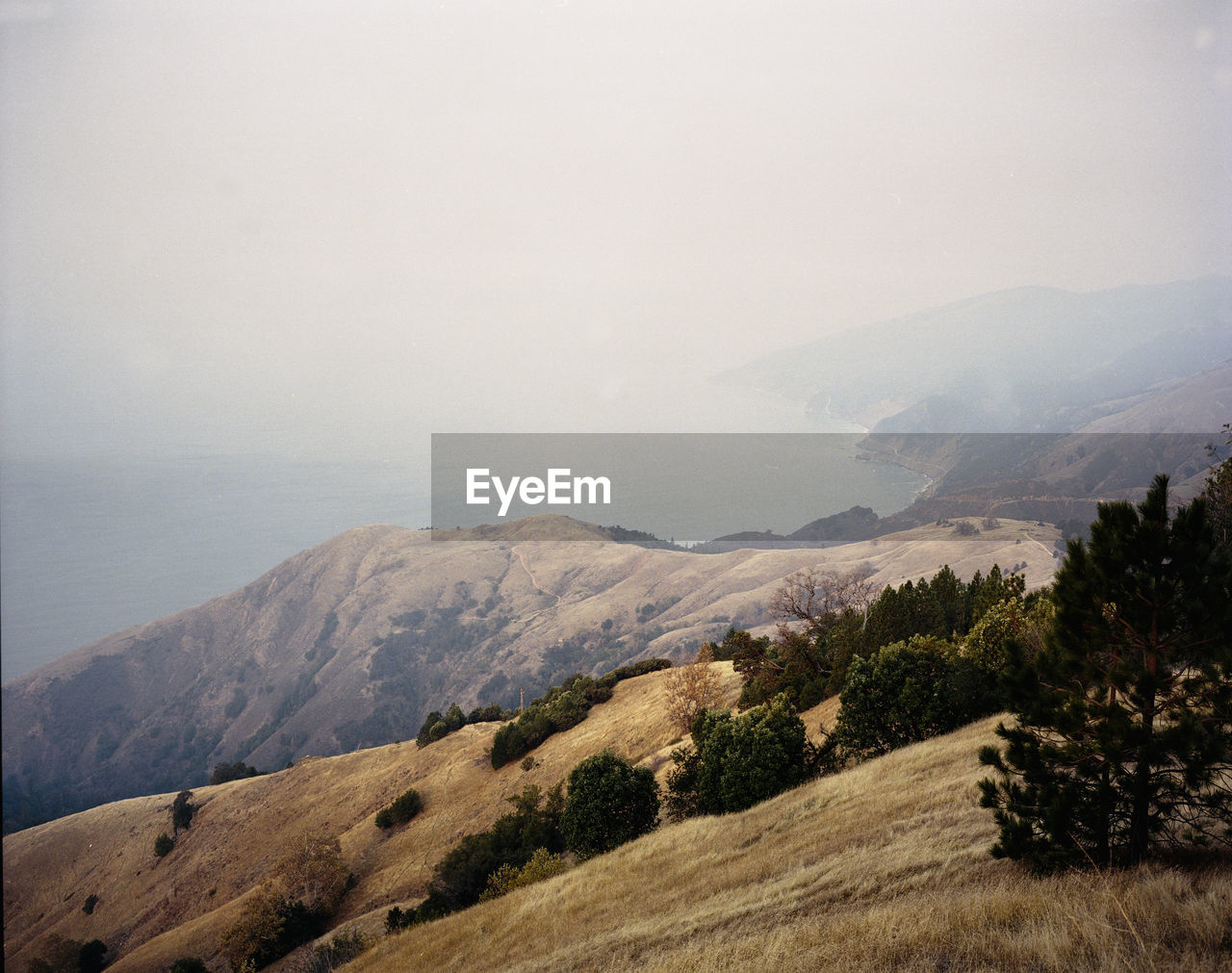 Big sur mountains in morning with layer of smoke from forest fir