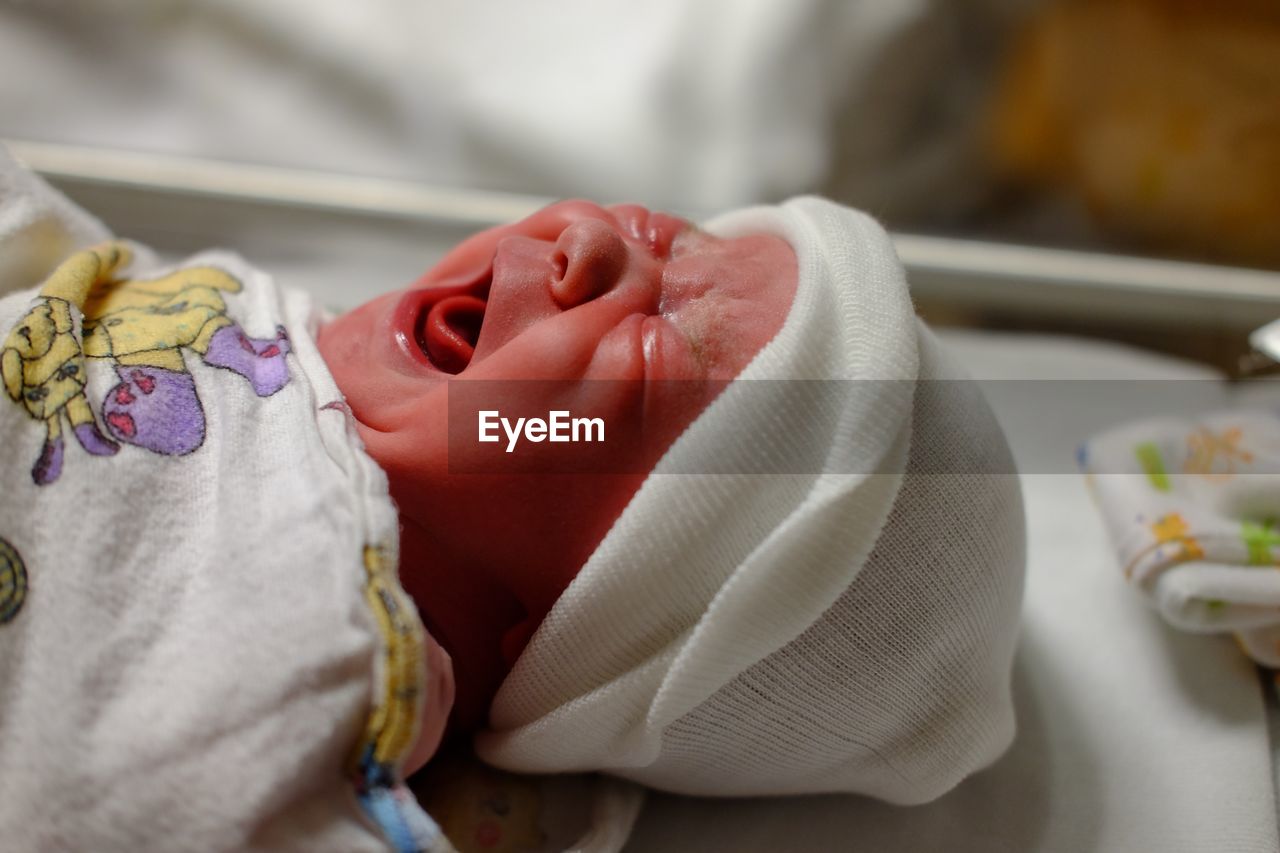 Close-up of cute baby girl screaming while crying in hospital