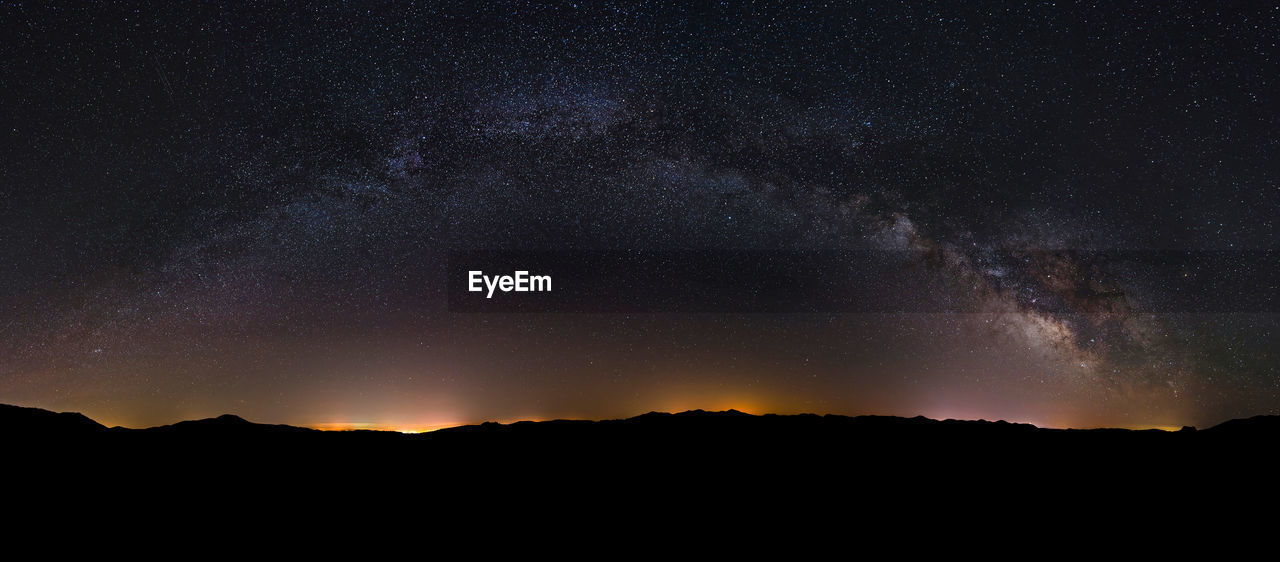 Scenic view of silhouette mountain against star field at night