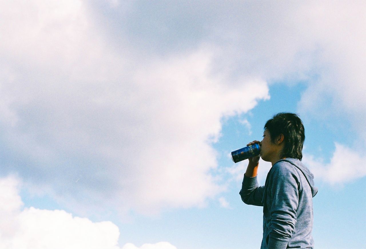 FULL LENGTH OF WOMAN STANDING AGAINST SKY