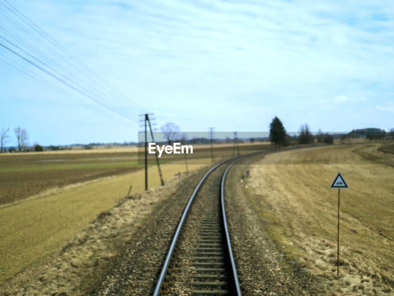 Railroad tracks on field against sky