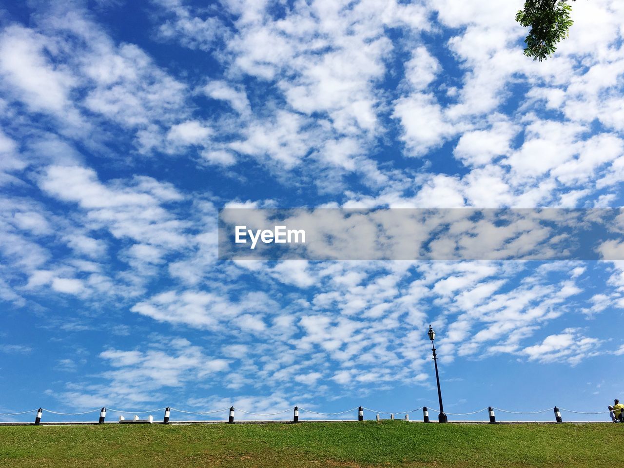 Scenic view of grassy field against cloudy sky