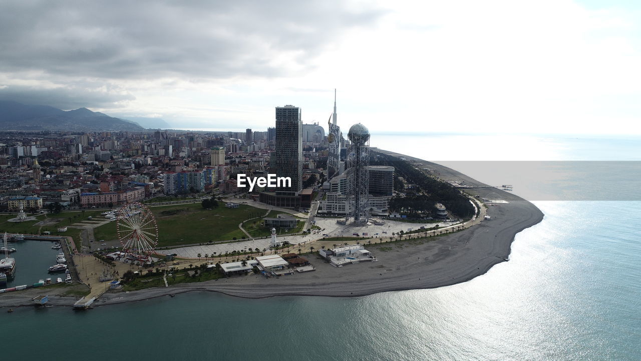 Aerial view of cityscape by sea against sky