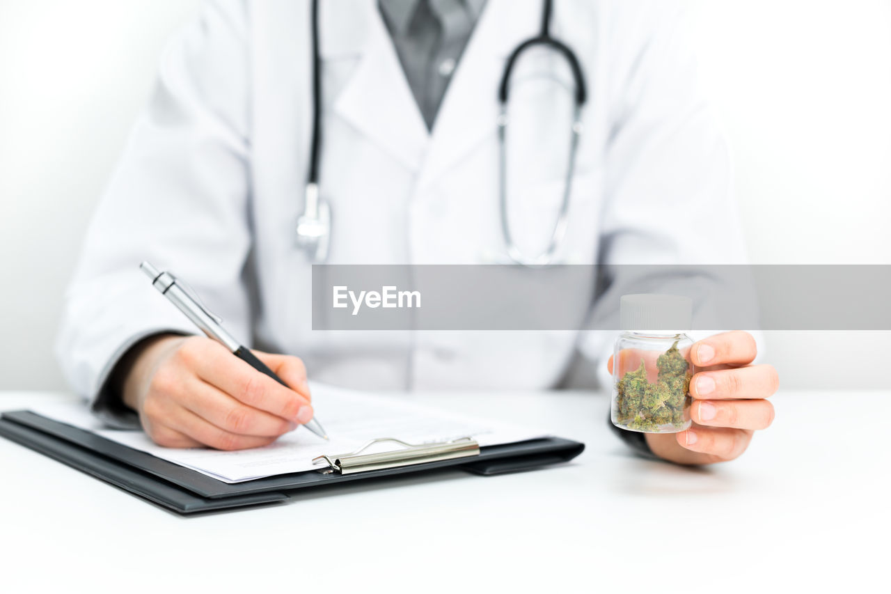 MIDSECTION OF PERSON HOLDING SMART PHONE