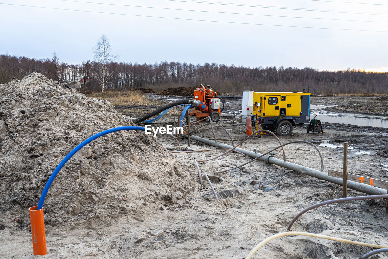 Wellpoint installation to get rid of high groundwater, visible metal pipes and large water pump.