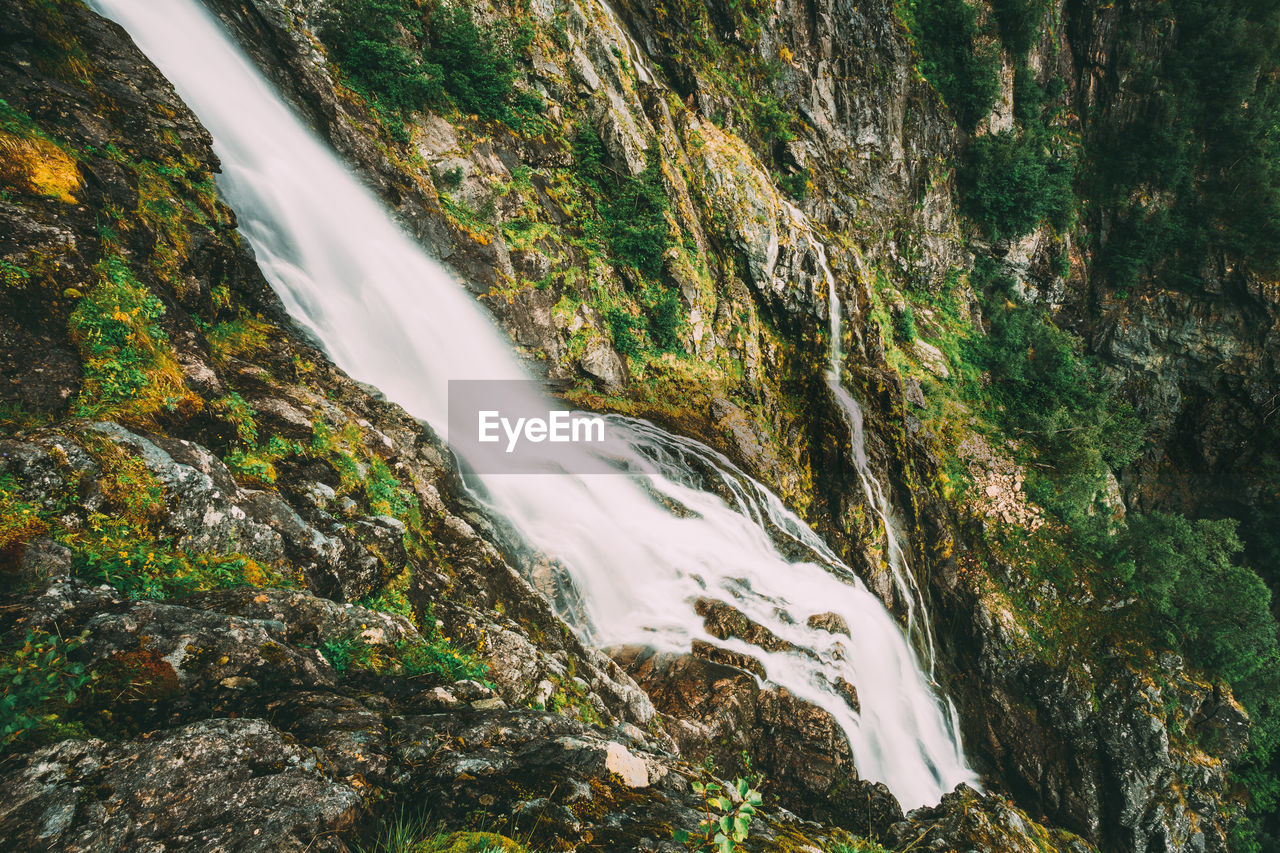 SCENIC VIEW OF WATERFALL AGAINST ROCK