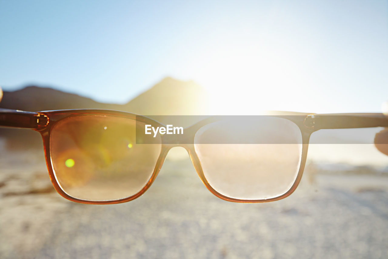 close-up of sunglasses on sand