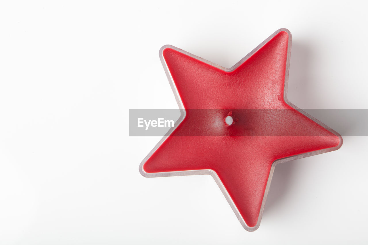Close-up of star shape christmas candle over white background