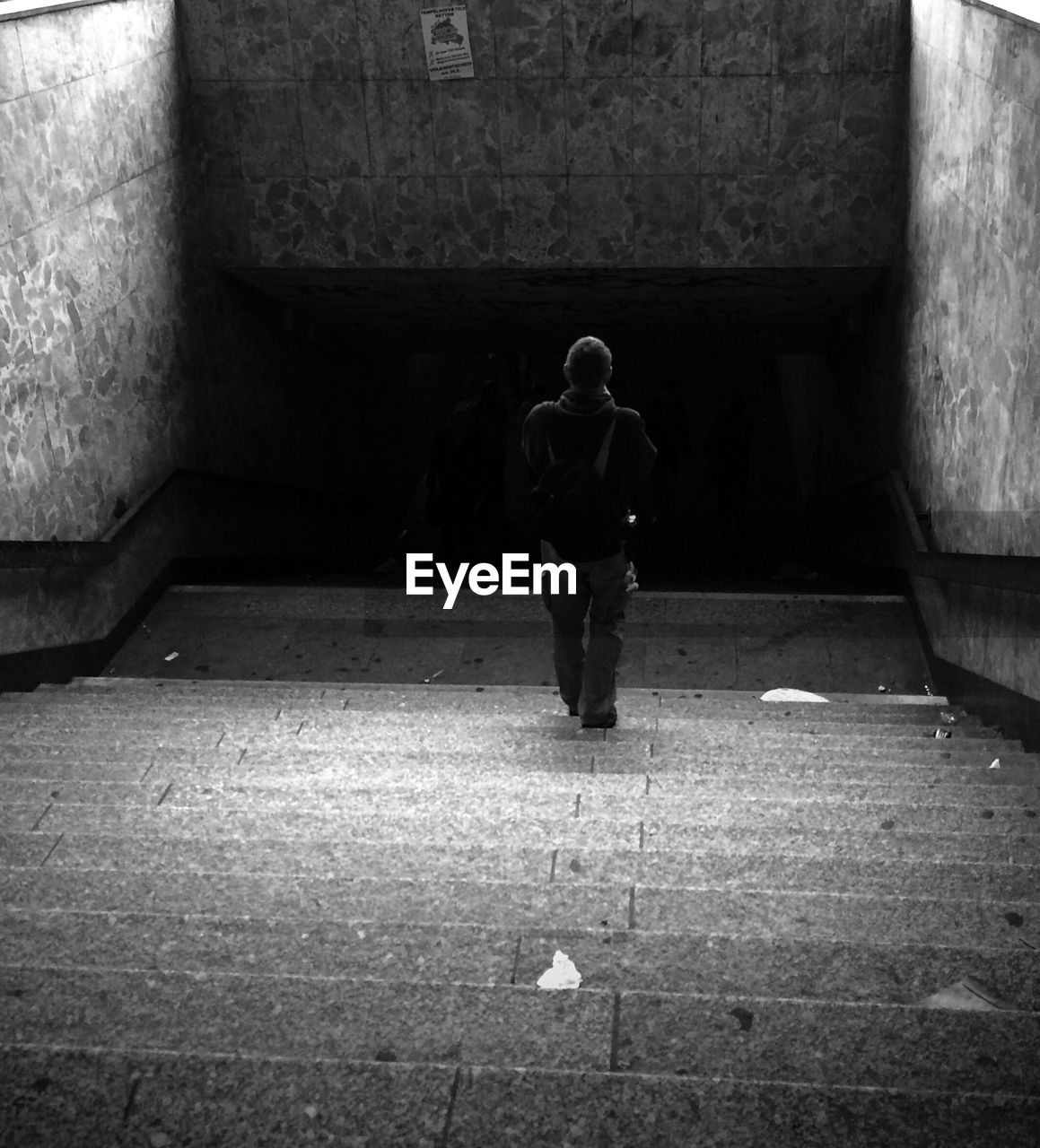 Rear view of man walking on staircase toward subway