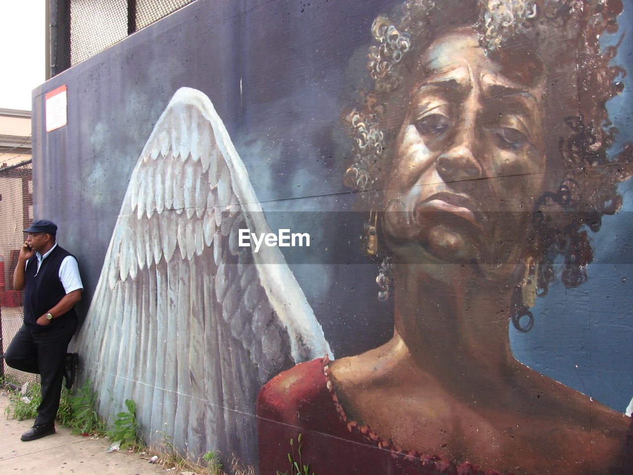 WOMAN STANDING AGAINST WALL