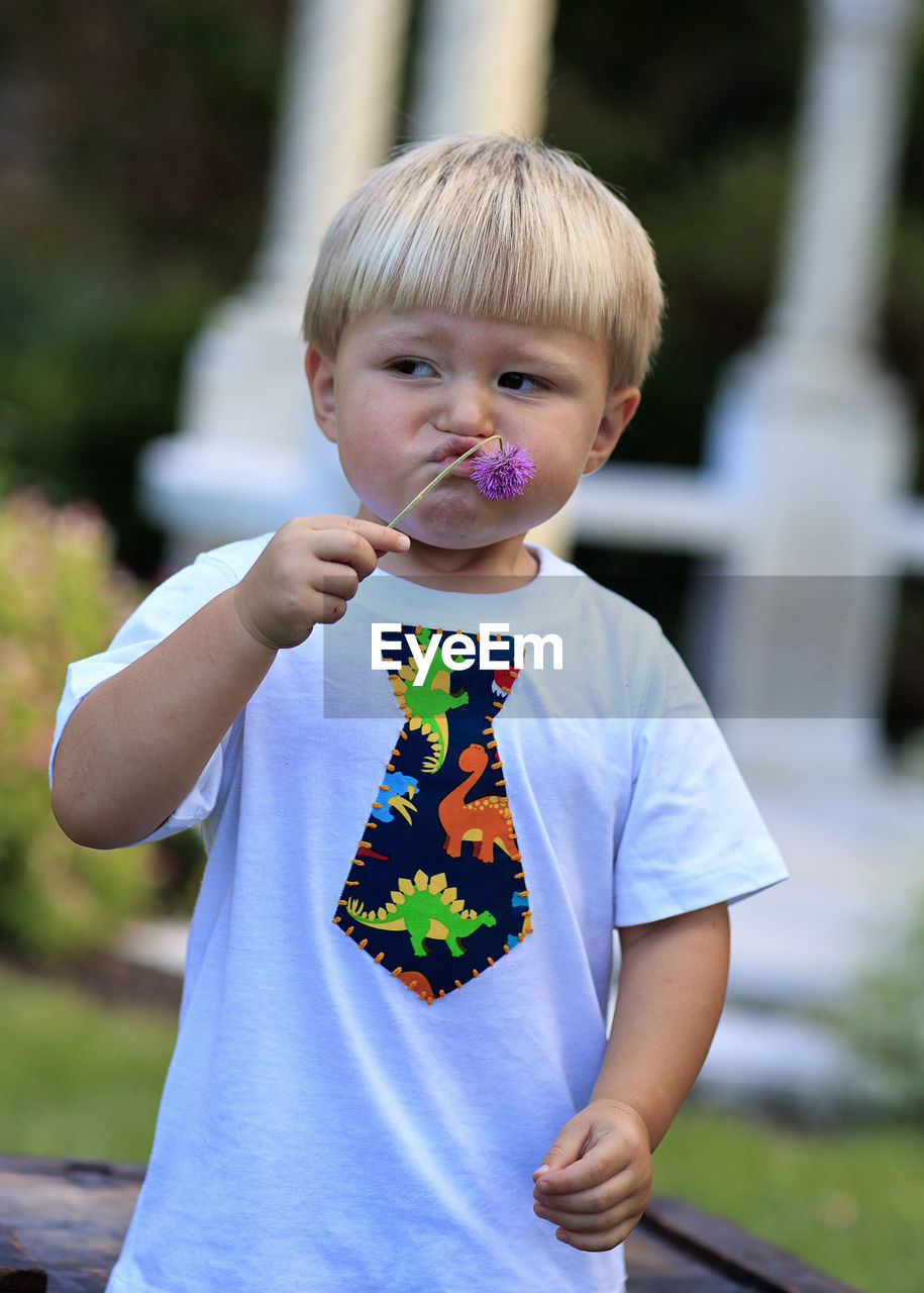 Portrait of boy smelling flower