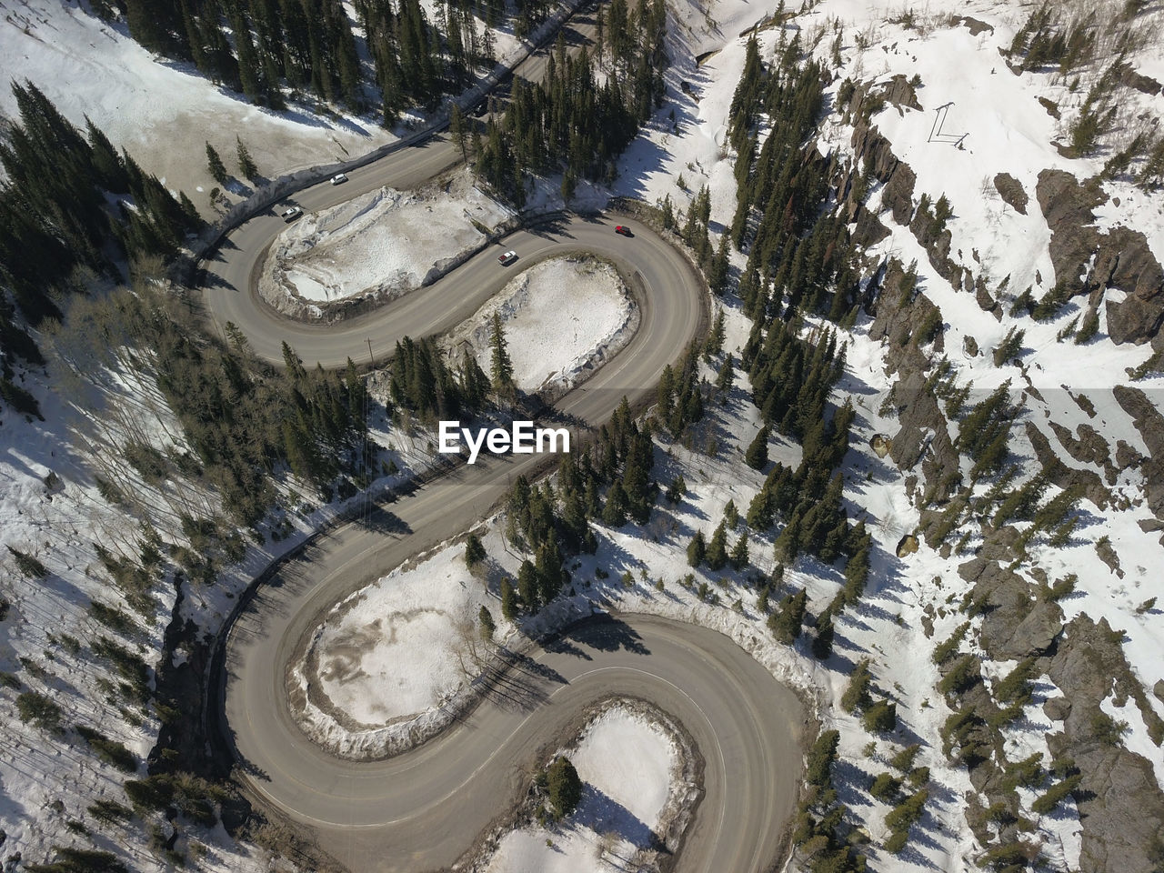 High angle aerial view of winding mountain road on snow covered mountain