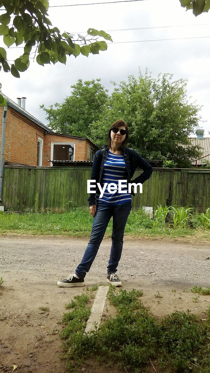 Woman standing on road against sky