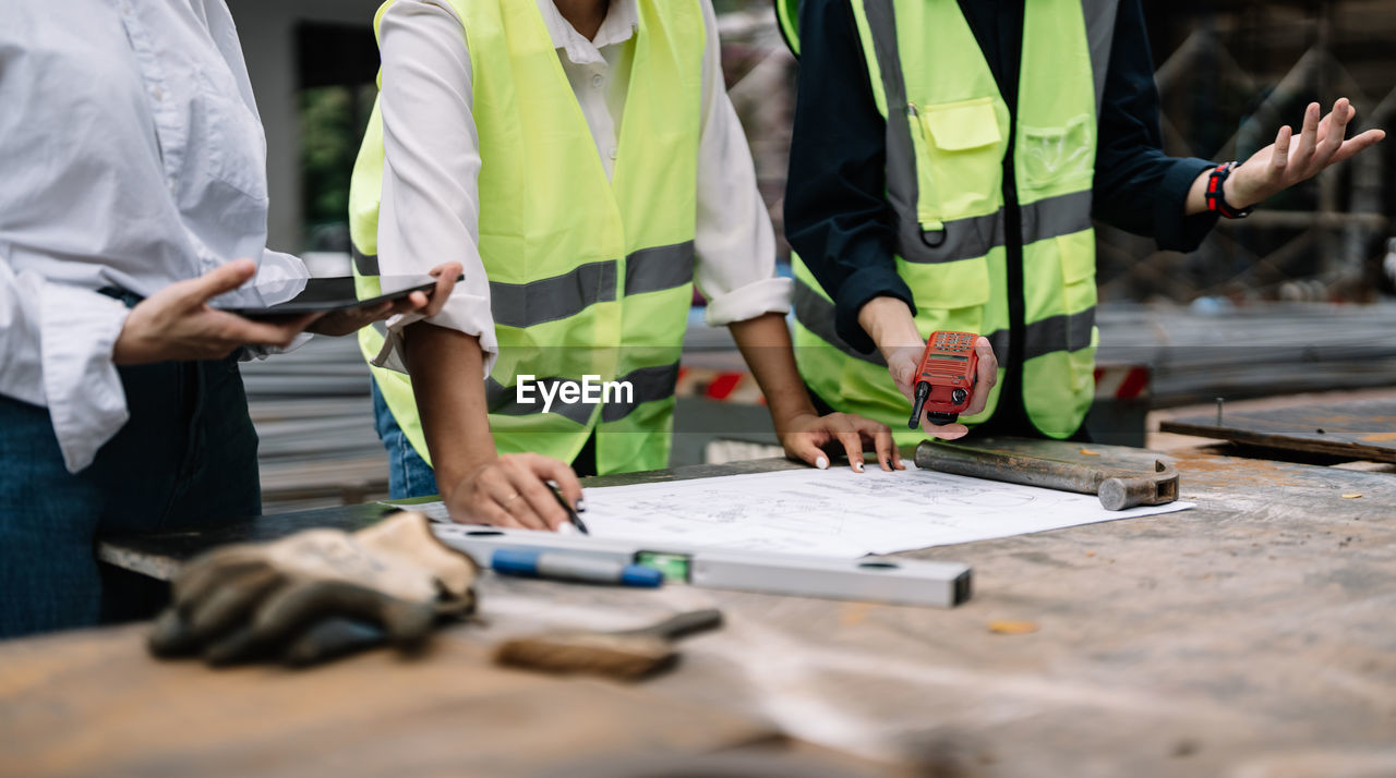 midsection of business people working on table