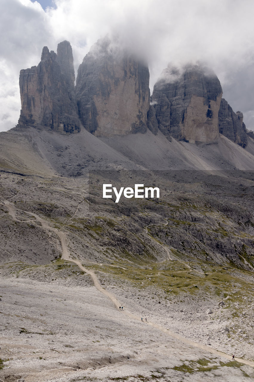 Scenic view of rock formations against cloudy sky