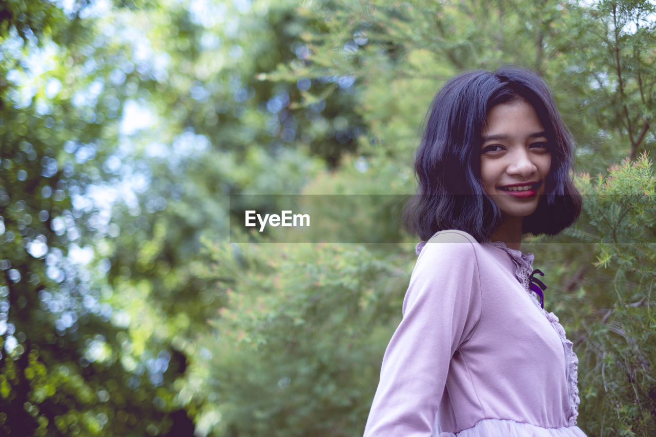 Portraits smiling asian young girl with pine tree in vintage color.