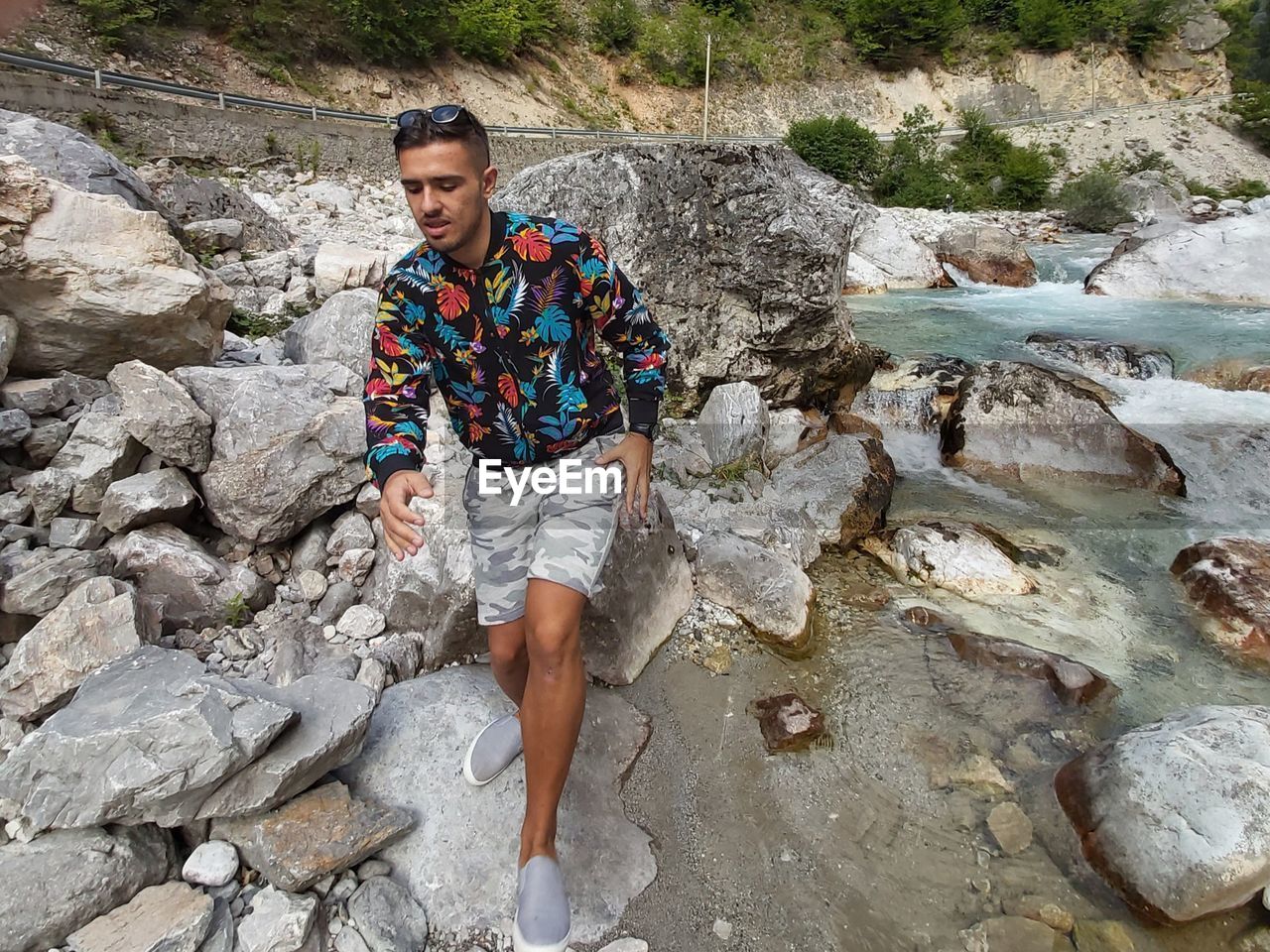 High angle view of young man standing by rock