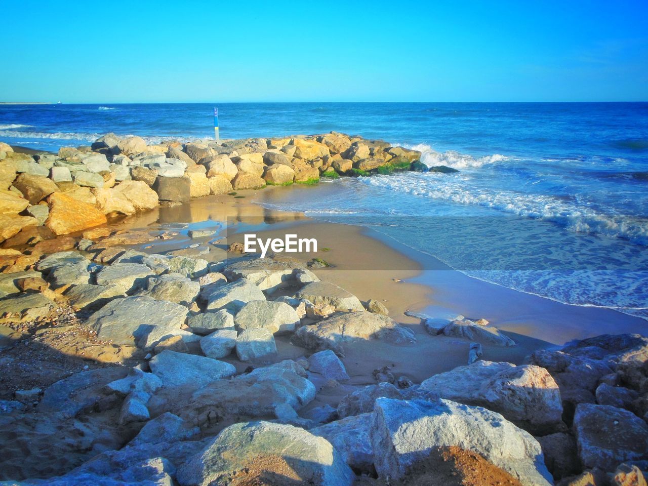 ROCKS ON BEACH AGAINST SKY