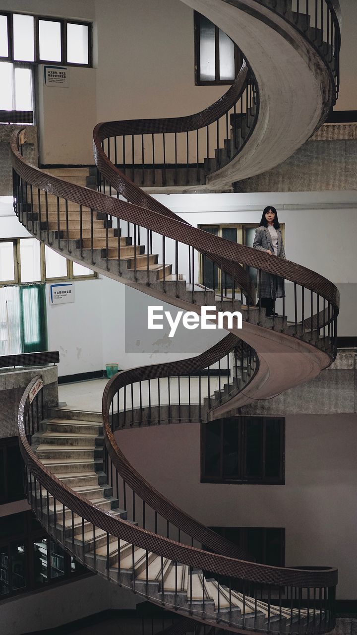 Woman standing on spiral staircase